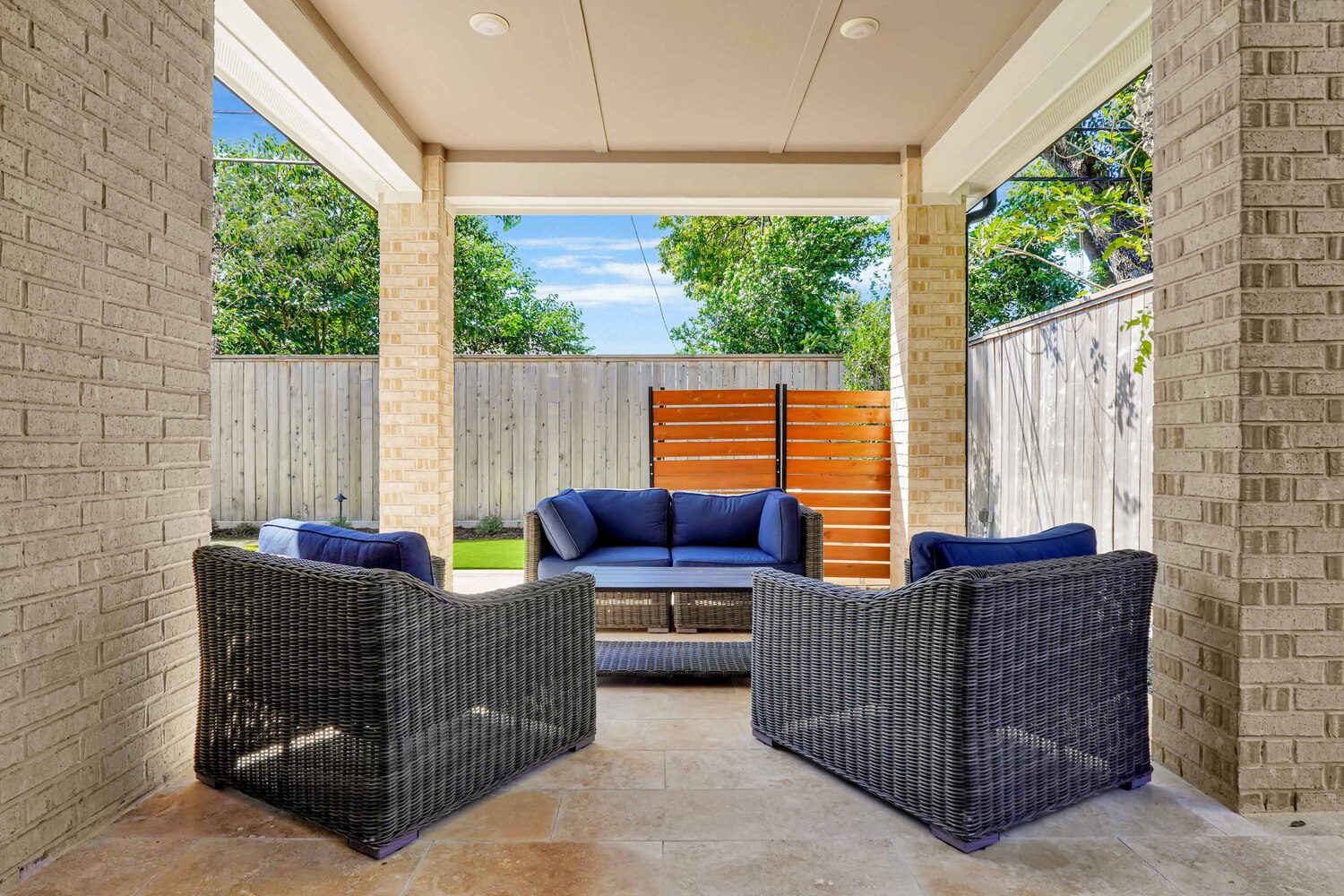 Patio with woven chairs and blue cushions - Orion Turf and Landscape
