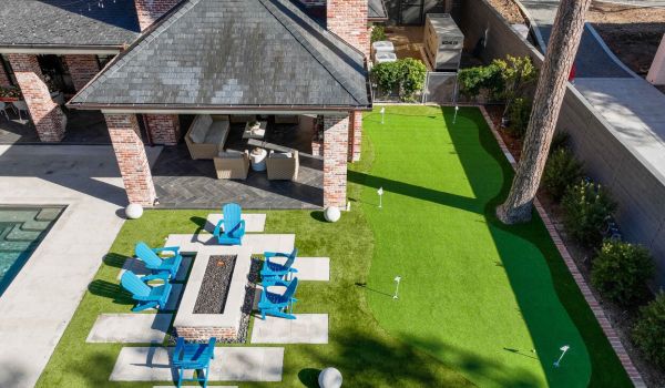Backyard with patio, outdoor firepit, and putting greens - Orion Turf and Landscape